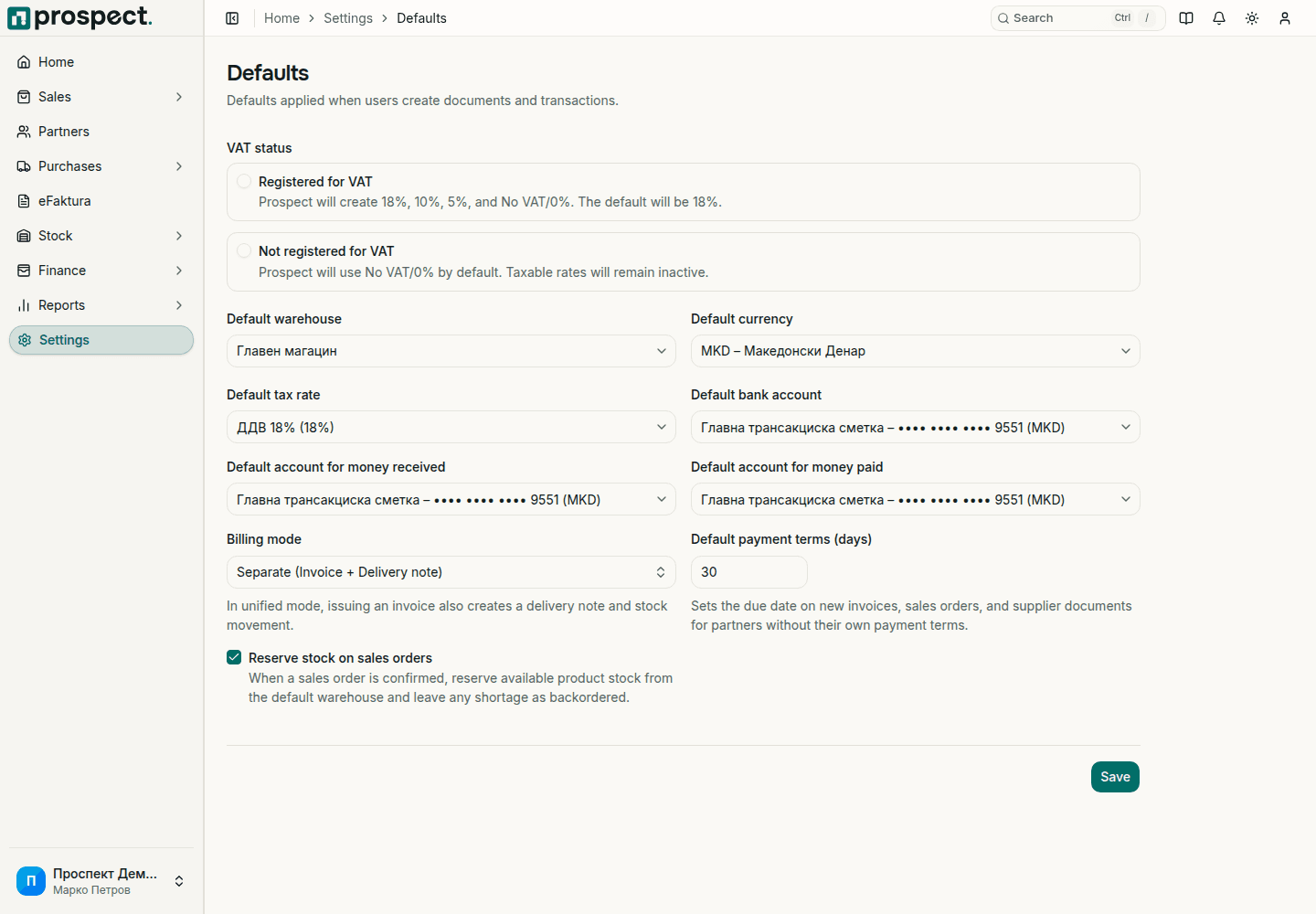 Defaults page with VAT status, default warehouse, currency, tax rate, bank accounts for money received and paid, billing mode, default payment terms and the Reserve stock on sales orders option